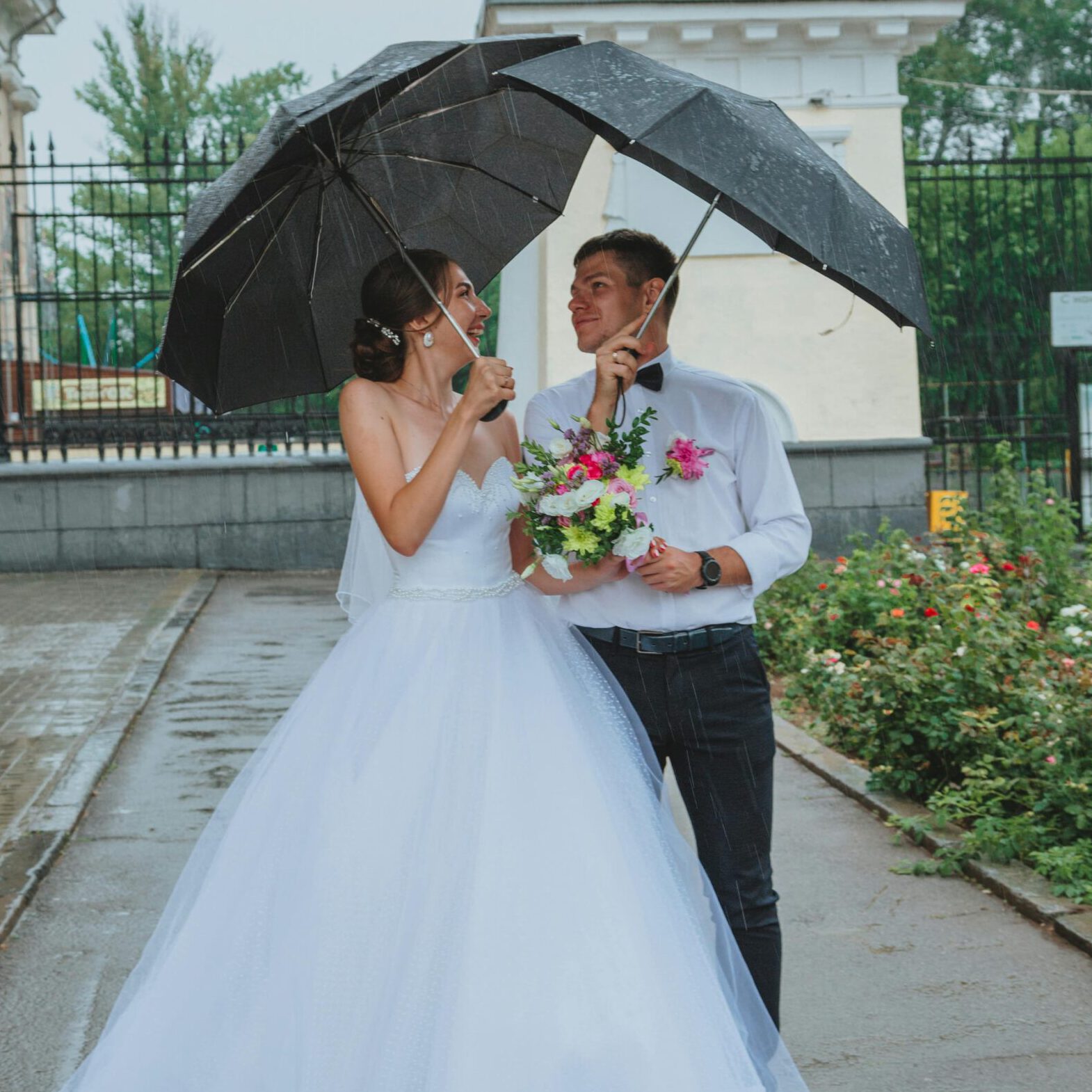 Hochzeit bei Regen, Brautpaar mit Regenschirm